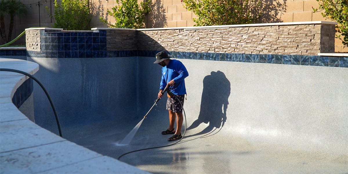 Pool draining company pressure washing a drained Peoria swimming pool