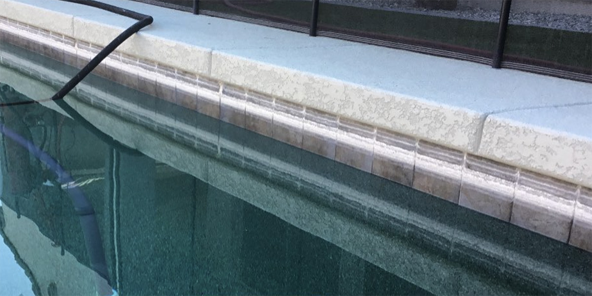 White calcium buildup line on swimming pool tiles