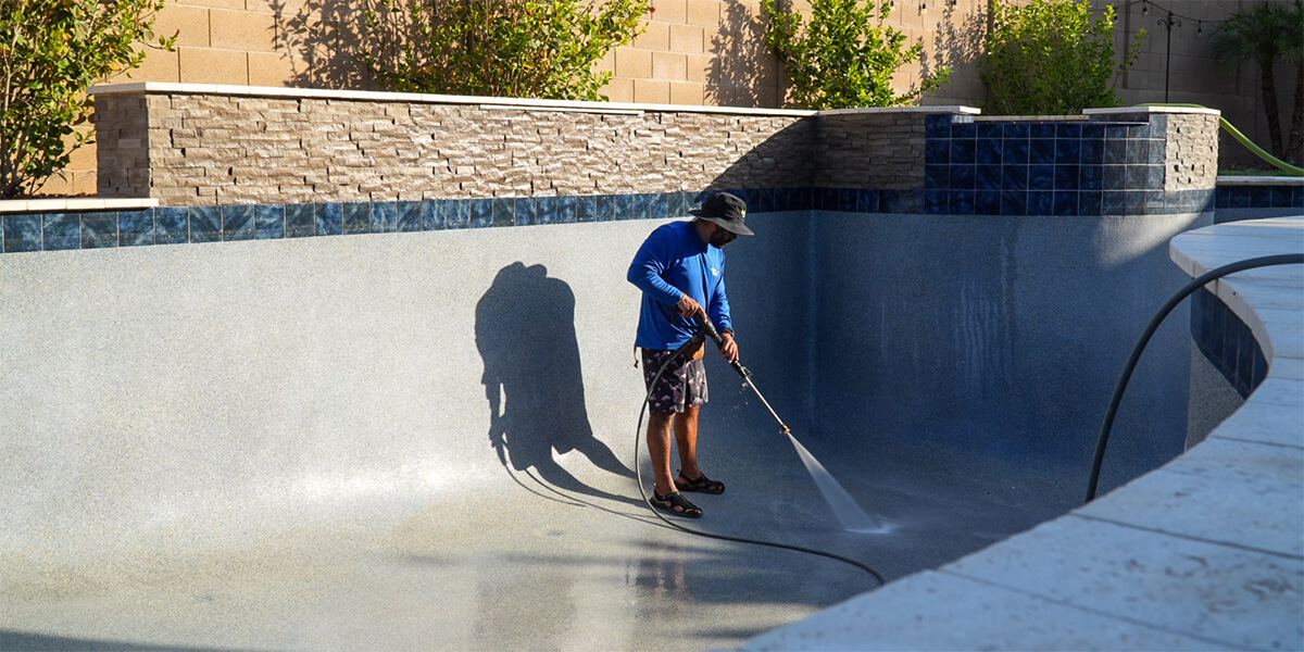 Pool company cleaning a freshly drained pool after 2 years elapsed